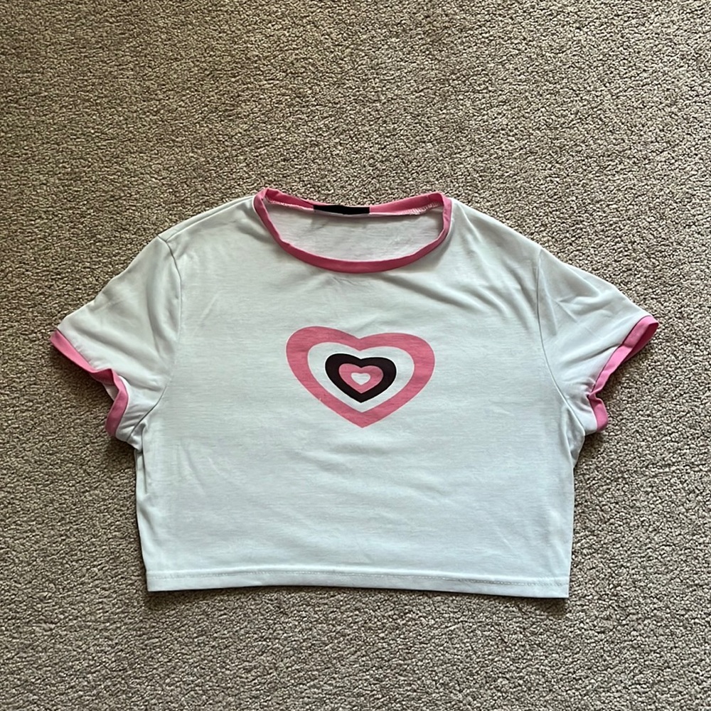 White crop top with pink heart and sleeve and collar details.